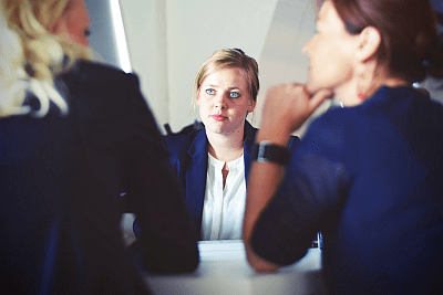 woman talking to two others in business meeting